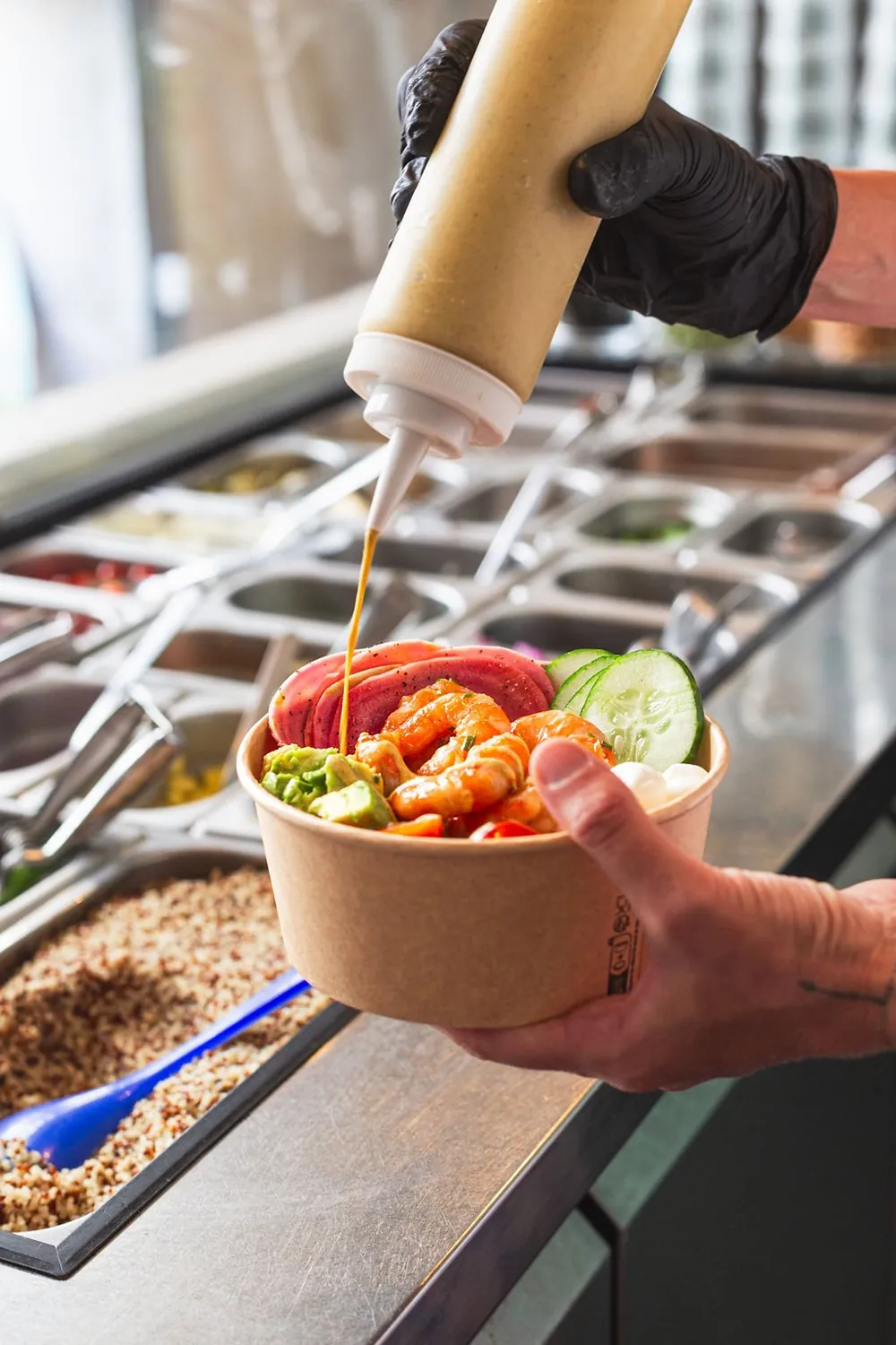 Hausgemachte Sauce, frisch über eine Poke Bowl gegossen